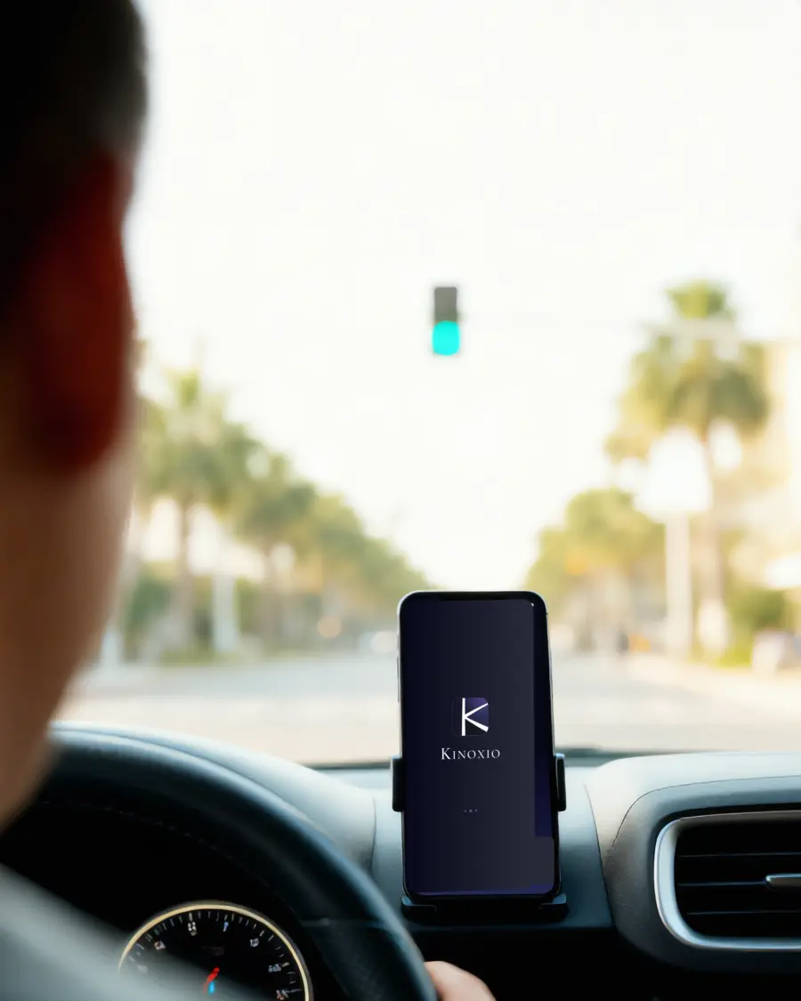 A Kinoxio driver on the road with the app mounted on the dashboard